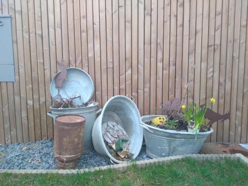 tres ollas con plantas en ellas al lado de una valla en Gîte Le Framboisier V de la distillerie Bio Spirit Belgium, en Neufchâteau