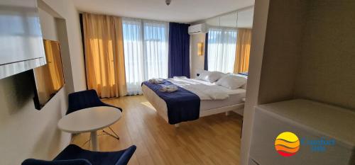 sypialnia z łóżkiem, stołem i krzesłami w obiekcie Comfort Inn ☆ Orbi City w mieście Batumi