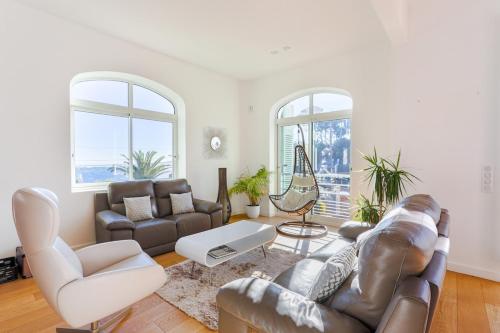 a living room with a leather couch and chairs at Villa Élégante Nice avec Vue Mer in Nice