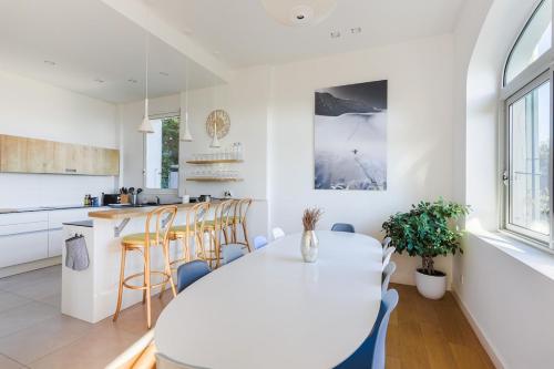 a kitchen and dining room with a white table and chairs at Villa Élégante Nice avec Vue Mer in Nice