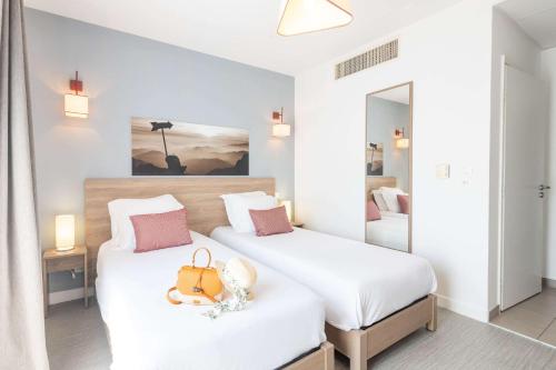 Rúm í herbergi á Comfort Aparthotel Cannes Mandelieu