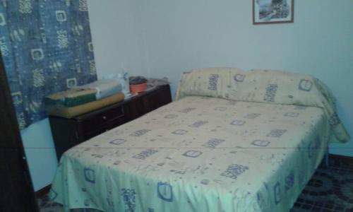 - une petite chambre avec un lit et une couverture dans l'établissement Sierras Chicas La Granja, à Córdoba