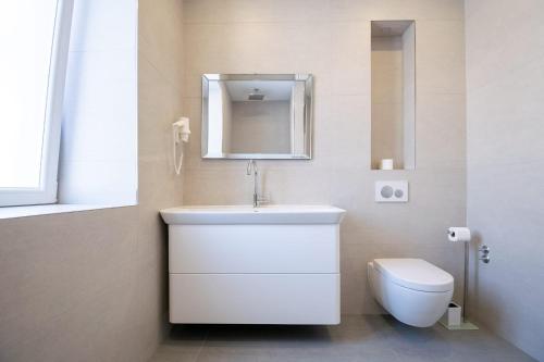 uma casa de banho com um lavatório branco e um WC. em Stone house em Baška Voda