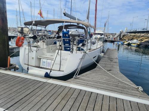 um barco está ancorado numa doca na água em Sleep aboard a modern sailboat in Oeiras em Oeiras