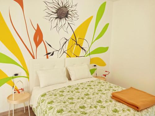 a bedroom with a bed with a flower mural on the wall at Sleep & Fly Villa Luisa in Case Nuove