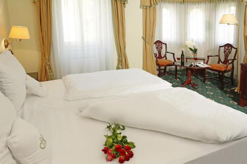 ein Hotelzimmer mit 2 Betten mit Blumen darauf in der Unterkunft Hotel Mignon in Karlsbad