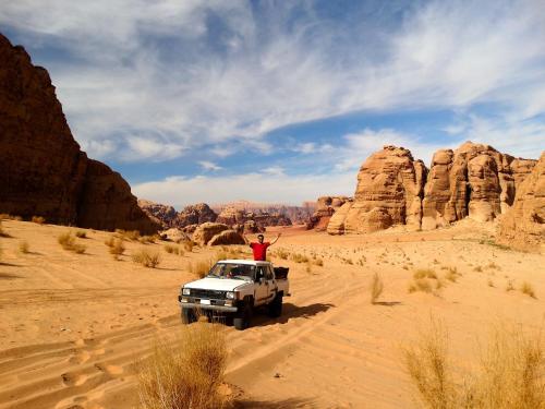 a white truck driving through the desert at Wadi rum view camp in Wadi Rum