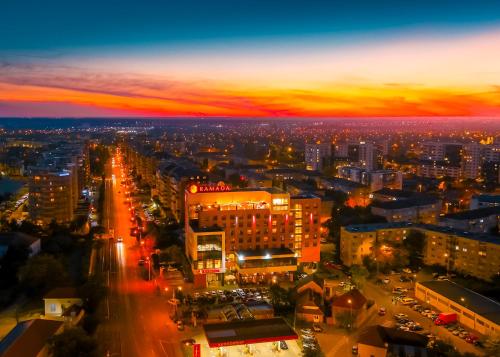 une vue aérienne de nuit sur une ville dans l'établissement Ramada by Wyndham Oradea, à Oradea