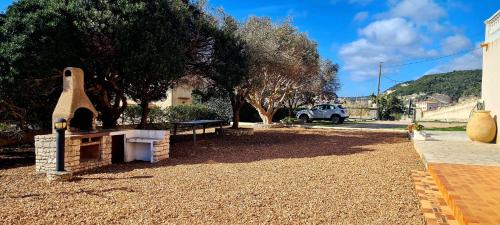 een park met een picknicktafel en een steenoven bij Appartement Kallisté, Logements avec vue citadelle de Bonifacio in Bonifacio