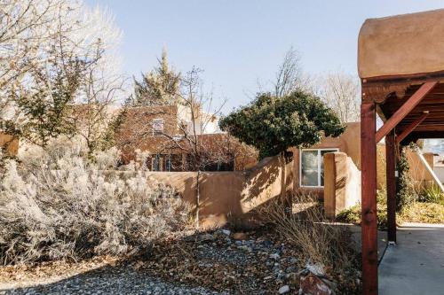 een oud gebouw met een hek in een tuin bij Group Getaway: Serene Adobe Retreat 4-11 guests in Albuquerque