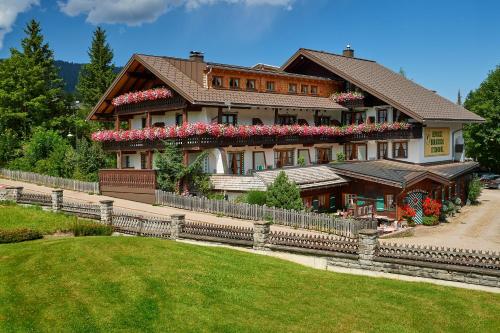 Una casa grande con flores al costado. en Biohotel Walserstuba, en Riezlern