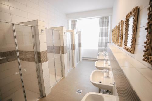 La salle de bains est pourvue d'une rangée de lavabos et de toilettes. dans l'établissement Second Home Hotel, à Merseburg