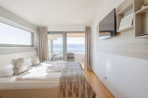 1 dormitorio con cama y ventana grande en Rogač Rooms & Restaurant, en Omiš