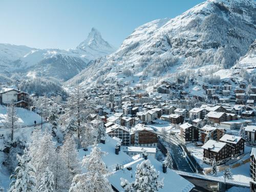 miasto pokryte śniegiem z górą w tle w obiekcie Relais & Chateaux Schönegg w mieście Zermatt