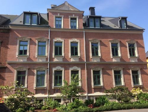 a large red brick building with many windows at Ferienwohnung Auszeit in Chemnitz