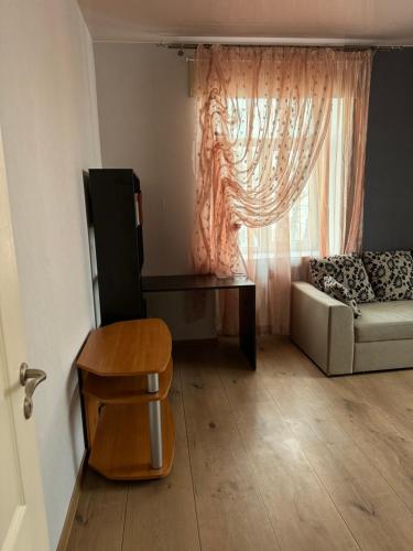 sala de estar con sofá, mesa y ventana en Apart Kesklinn, en Kohtla-Järve