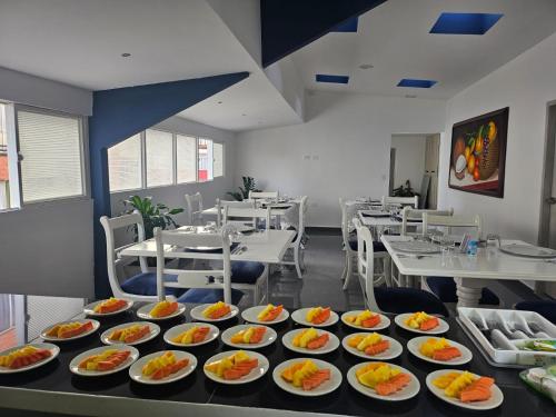 un restaurant avec de nombreuses assiettes de nourriture sur une table dans l'établissement Hotel San Jeronimo Armenia, à Armenia