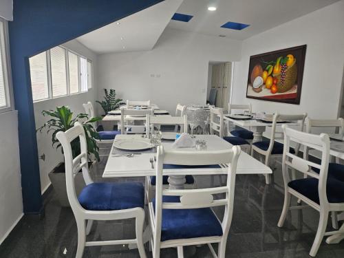 une salle à manger avec des tables et des chaises blanches dans l'établissement Hotel San Jeronimo Armenia, à Armenia