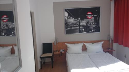 una camera da letto con un letto con lenzuola bianche e uno specchio di Hotel Novostar a Kassel