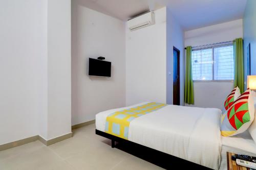 1 dormitorio blanco con 1 cama y TV en Home Exotic Stay Bsk 3rd Stage, en Bangalore