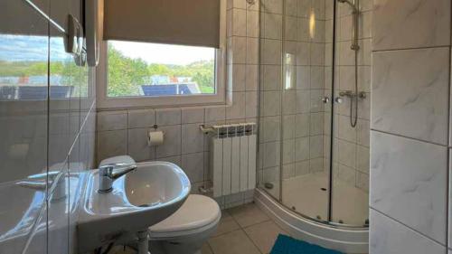 a bathroom with a sink and a shower and a toilet at Kwatery u Papieżów in Biały Dunajec