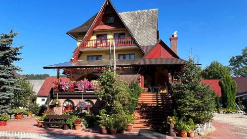 uma casa grande com telhado vermelho em Kwatery u Papieżów em Biały Dunajec