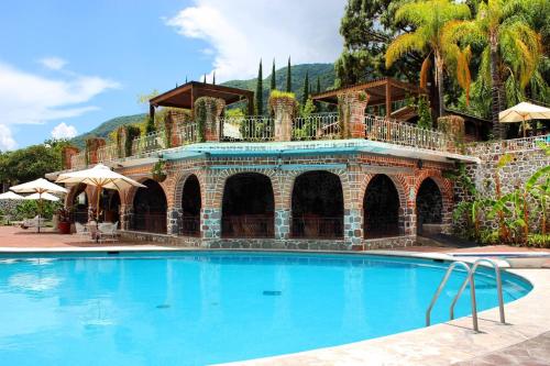 una grande piscina di fronte a una casa di Mama Chuy Hotel & Villas a San Juan Cosalá