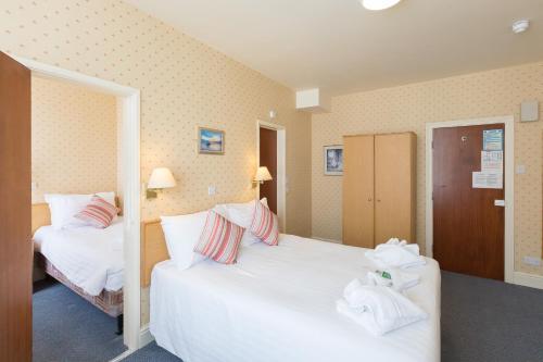 een hotelkamer met 2 bedden en handdoeken erop bij Eliot Hotel in Newquay