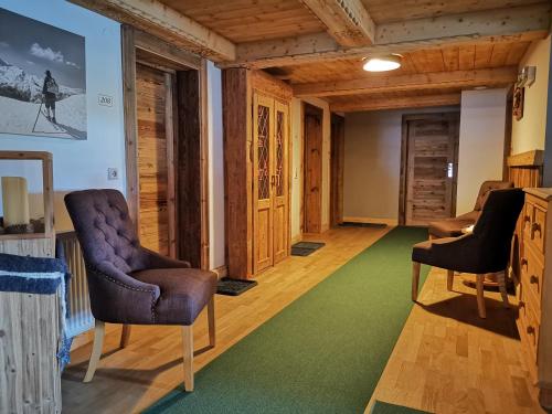 - un salon avec deux chaises et un tapis vert dans l'établissement Gasthaus Auwirt, à Fieberbrunn