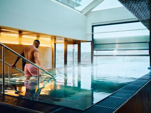 Un uomo in acqua in una piscina di Clarion Hotel Stockholm a Stoccolma