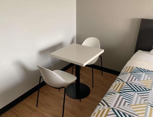 une chambre avec une table et deux chaises à côté d'un lit dans l'établissement Studio 6-Lincoln, NE - Airport, à Lincoln