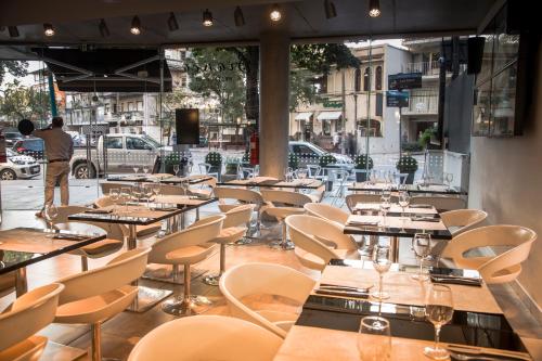 una fila di tavoli e sedie in un ristorante di Vivaldi Hotel Loft Punta Carretas a Montevideo