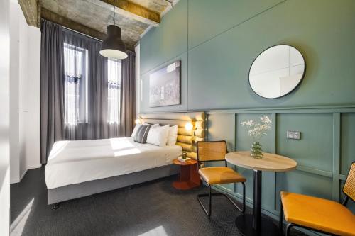 um quarto de hotel com uma cama e uma mesa em The Urban Newtown em Sidney