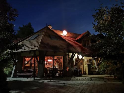 ein Haus mit Licht auf dem Dach in der Nacht in der Unterkunft Napkorong Fogadó és Vendégház in Piliscsaba