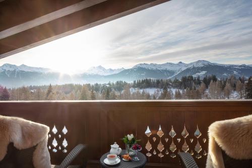 um quarto com uma grande janela com vista para as montanhas em Guarda Golf Hotel & Residences em Crans-Montana