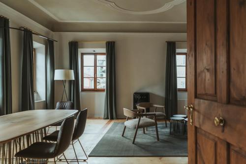 Arthotel Lasserhaus - adults only في Brixen: غرفة معيشة مع طاولة وكراسي