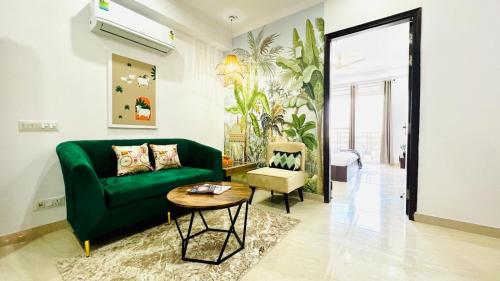 a living room with a green couch and a table at ZEN Suites - Golf Course Road Gurgaon in Gurgaon