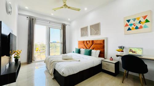 a bedroom with a large bed and a large window at ZEN Suites - Golf Course Road Gurgaon in Gurgaon