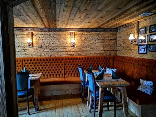 une salle à manger avec des murs en bois et des chaises bleues dans l'établissement Gasthaus Auwirt, à Fieberbrunn