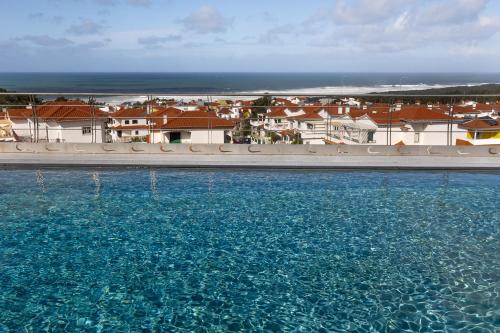 un grand bassin d'eau avec des bâtiments en arrière-plan dans l'établissement Océane Guest House - Adults only, à Nazaré