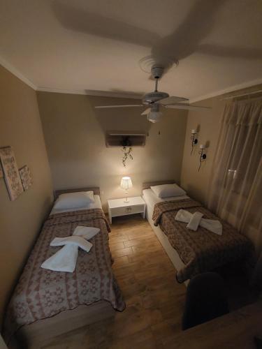 een slaapkamer met 2 bedden en een plafondventilator bij ALICE'S ARt HOUSE in Kavala