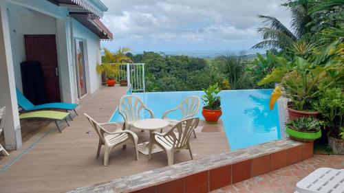 un patio con tavolo e sedie sul balcone. di La Villa Rosier a Le François