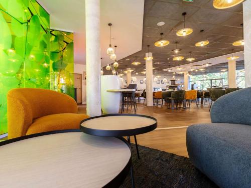 una hall con sedie e tavolo e un angolo bar con servizio di vendita di asterisco. di ibis Styles Troyes Centre a Troyes