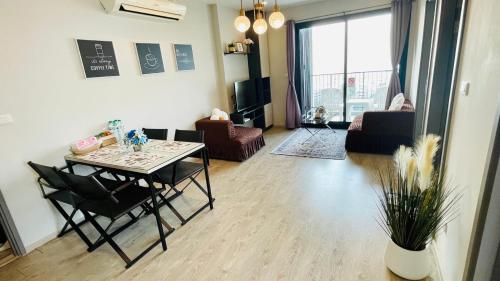 The base Central Pattaya 2 bed 1 bath by Numam في باتايا سنترال: غرفة معيشة مع طاولة وكراسي