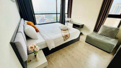 The base Central Pattaya 2 bed 1 bath by Numam في باتايا سنترال: غرفة نوم بسرير ونافذة وكرسي