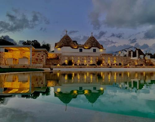 a building with a reflection in the water at night at Borgofreddo Luxury Suite in Monopoli