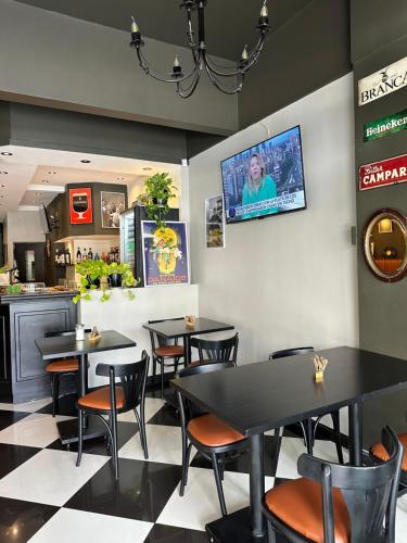 un restaurant avec des tables et des chaises ainsi qu'une télévision murale. dans l'établissement Lolo Hotel Boutique, à Mar del Plata