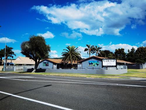 um edifício com uma placa na berma de uma estrada em Cortez Motel em Whakatane