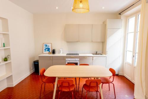 - une cuisine avec une table et des chaises orange dans l'établissement Villa CANA, à Cannes