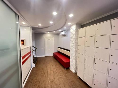 a room with a red bench in a room with white cabinets at Like Hostel in Chişinău